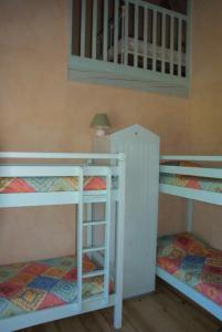 two bunk beds in a room with a lamp at Maison sous les arbres in Lit-et-Mixe