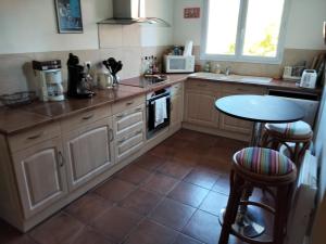 a kitchen with a table and a counter top at Maison sous les arbres in Lit-et-Mixe