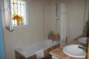 a bathroom with a tub and two sinks and a window at Maison sous les arbres in Lit-et-Mixe +9 photos