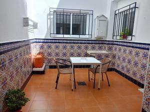 a table and chairs in a room with tiles at Casa Feria in Algodonales