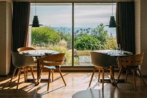 a dining room with a table and chairs and a large window at Bedruthan Hotel & Spa in Newquay