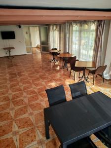 a room with tables and chairs and a flat screen tv at Vila njoy by the sea in Eforie Sud