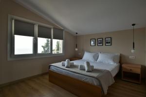 a bedroom with a large bed with two white pillows at theaSee Sea & Mountain View in Nea Irakleia