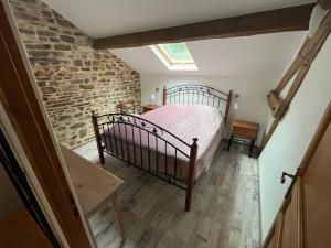 a bedroom with a bed and a brick wall at Liabaquet Gîtes in Sarlande +31 photos