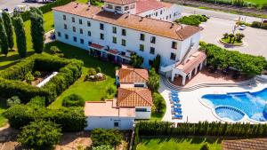 an aerial view of a large white house with a swimming pool at Hotel Restaurant Bon Retorn in Figueres