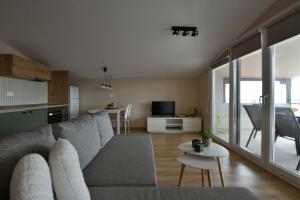 a living room with a gray couch and a kitchen at theaSee Sea & Mountain View in Nea Irakleia