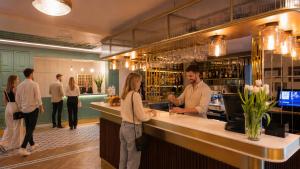 a man and woman standing at a bar in a restaurant at Villa Herkules - Adults Only in Świnoujście