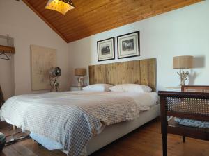 a bedroom with a large bed and a wooden ceiling at Suite no campo in Cercal