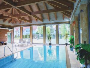 an indoor swimming pool with chairs and windows at Inselhotel Poel in Gollwitz