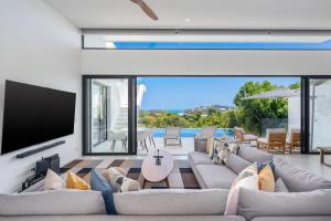 a living room with a large couch and a tv at Horizon Villas Samui in Choeng Mon Beach