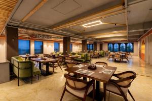 a restaurant with tables and chairs and windows at Devi Palace - Monsoon Palace View Resort, Udaipur in Udaipur