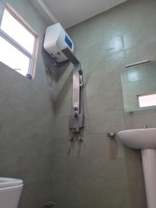 a bathroom with a toilet and a soap dispenser on the wall at Holiday Inn in Colombo