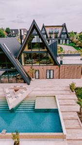 a house with a swimming pool in front of it at By The Lake - A Frame in Căciulaţi