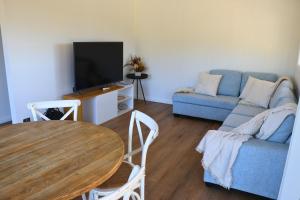 a living room with a blue couch and a table at Tangory Farmstay in Glendon Brook