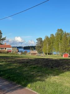 a view of a field with houses and a lake at Stugan i Gesunda in Sollerön