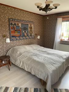 a bedroom with a bed and a painting on the wall at Stugan i Gesunda in Sollerön