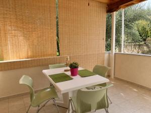 a white table and chairs in a room with windows at ALIO Seaside Maisonette, Steps from Diakopto Beach in Diakopto