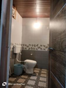 a bathroom with a toilet and a light on the ceiling at Trippr Gokarna - Beach Hostel in Gokarna