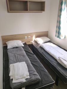 two beds sitting next to each other in a room at Séjour à litteau in Litteau