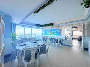 a dining room with white tables and white chairs at Hotel Pineda Playa in Noja