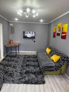 a living room with a couch and a table at Квартира 1 линия in Balqash
