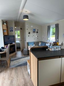 a living room with a kitchen and a living room with a table at Bang Tidy 261 - Cabin - Wifi - Pool - Sleep 6 in Paignton