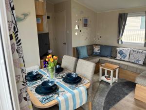 a living room with a table and a couch at Bang Tidy 261 - Cabin - Wifi - Pool - Sleep 6 in Paignton +41 photos