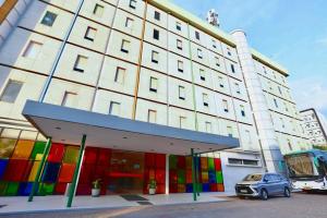 a large building with colorful windows and a car parked in front at TreePark Hotel Jakarta Airport in Tangerang