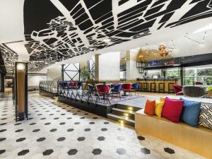 a lobby with a couch and tables and chairs at ibis Budapest Castle Hill in Budapest