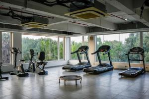 ein Fitnessstudio mit vielen Ergometern in einem Raum mit Fenstern in der Unterkunft Devka Beach Resort in Daman