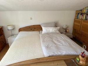 a bedroom with a large bed with white sheets at Gartenhaus - Dietzhäuschen in Suhl