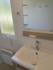 a bathroom with a white sink and a mirror at Séjour à litteau in Litteau