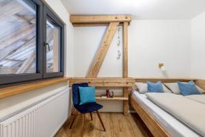 a bedroom with a window and a blue chair at Oberling in Herbrechtingen