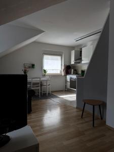 a kitchen and a living room with a table at Gemütlich unterm Dach in Baunatal +4 photos