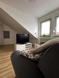 a living room with a couch and a flat screen tv at Gemütlich unterm Dach in Baunatal