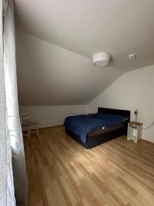 a bedroom with a bed and a wooden floor at Gemütlich unterm Dach in Baunatal