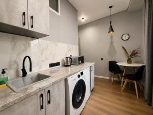 a kitchen with a washing machine and a sink at Nazarbayev avenue central studios in Almaty