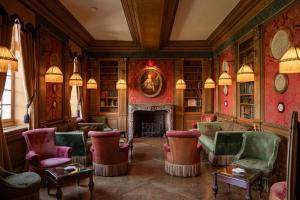 a living room with chairs and a fireplace at Château de Courcelles - Relais & Châteaux in Courcelles-sur-Vesle