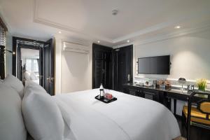 a bedroom with a white bed and a television at Sapa Boutique Hotel & Spa in Sapa