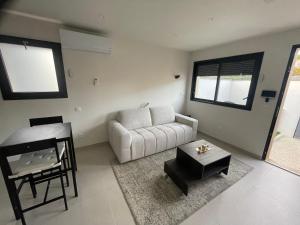 a living room with a white couch and a table at Studio cosy avec terrasse in Montpellier +1 photo