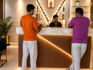 two men standing at a bar in front of a mirror at Sanctuary Boutique Hotel in Bhīm Tāl