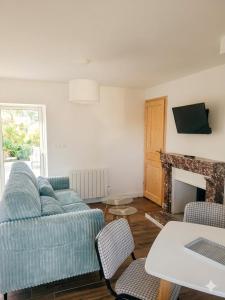 a living room with a blue couch and a fireplace at Domaine des Bichettes in Mareuil-sur-Lay