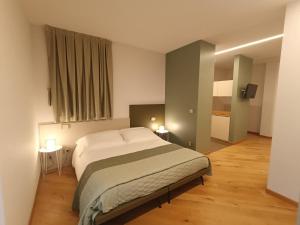 a bedroom with a bed and two tables and two lamps at HOTEL - BAR DA NATALE in Paesana +47 photos