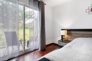 a bedroom with a bed and a large window at Casa Carmen in Cabouco