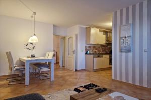 a living room and kitchen with a table and chairs at Ferienwohnung Graugans in Baabe +6 photos