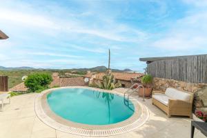 a swimming pool in a patio with a couch and a chair at Villa Roccia d'oro piscina privata in Porto San Paolo