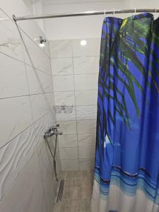 a shower with a blue shower curtain in a bathroom at Sea&Stay in Shëngjin +5 photos