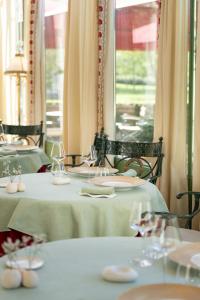 two tables with green table cloths and wine glasses at Château de Courcelles - Relais & Châteaux in Courcelles-sur-Vesle