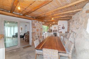 a kitchen and dining room with a wooden table at Villa Roccia d'oro piscina privata in Porto San Paolo