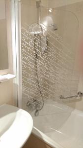 a shower with a faucet in a bathroom at Hôtel de France in Objat